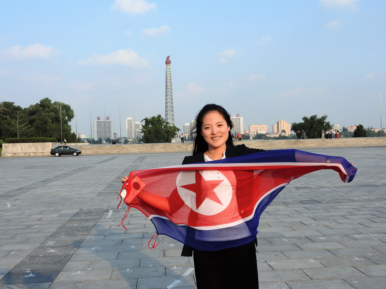 One of our hosts, Kim-Young, holding the flag of the DPRK. Behind her, the Juche tower, so-named after the dominant philosophy of self-reliance. Our other host, Kim Song-Nam, explained: “The Juche philosophy was created by President Kim Il-Sung. Man decides his own destiny, we rely on our own resources.”