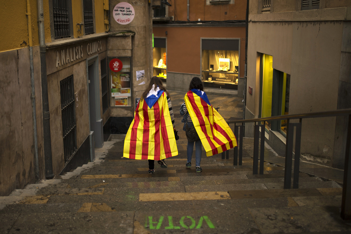 Women with "esteladas," or Catalonia independence flag, walk along the old quarter in Girona, Spain, Monday, Oct. 2, 2017. (AP/Francisco Seco)