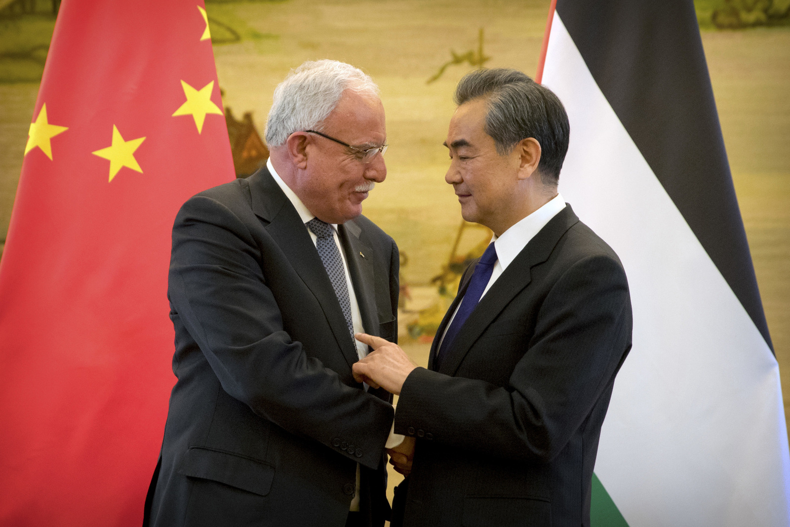 Palestinian Foreign Minister Riyad Al-Maliki, left, and Chinese Foreign Minister Wang Yi shake hands at the end of their joint press conference at the Ministry of Foreign Affairs in Beijing, Thursday, April 13, 2017. (AP/Mark Schiefelbein)