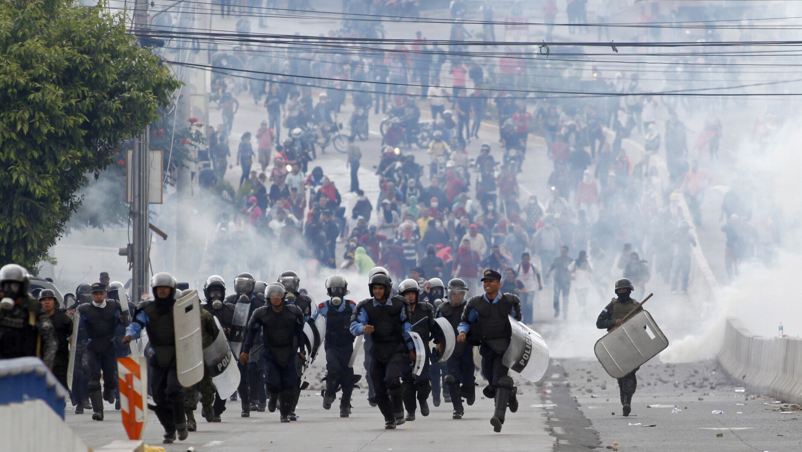 Police run away from supporters of opposition presidential candidate Salvador Nasralla after firing their last tear gas canisters at them, who threw it back at police near the institute where election ballots are stored in Tegucigalpa, Honduras, Nov. 30, 2017. Protests are growing as incumbent President Juan Orlando Hernandez emerged with a growing lead for re-election following a reported computer glitch that shut down vote counting for several hours. (AP/Fernando Antonio)