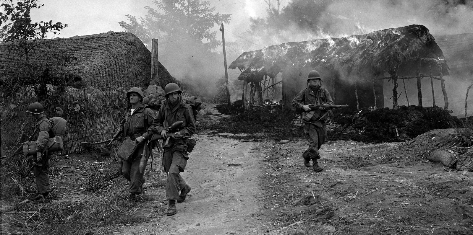 Des soldats américains passent à travers des cabanes en feu dans la région de Sunchon / Sukchon, en Corée du Nord, le 20 octobre 1950. (AP / Max Desfor)