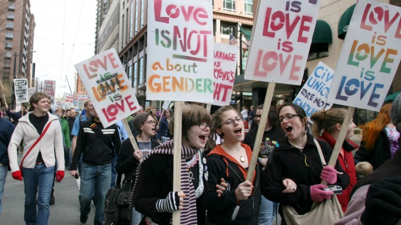 Activists marching with pro-LGBT marriage signs: Love Is NOT About Gender, Love Is Love Is Love.
