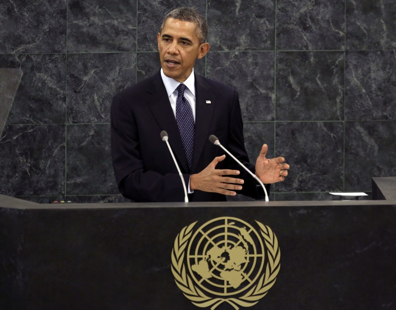 Barack Obama gestures with his hands as he speaks behind a United Nations podium.