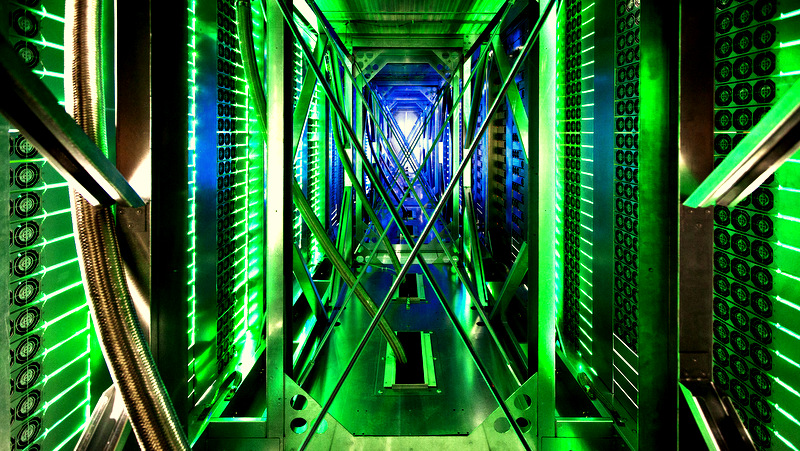 A seemingly endless corridor of fans stretches away from the camera, lit by green and blue lights.
