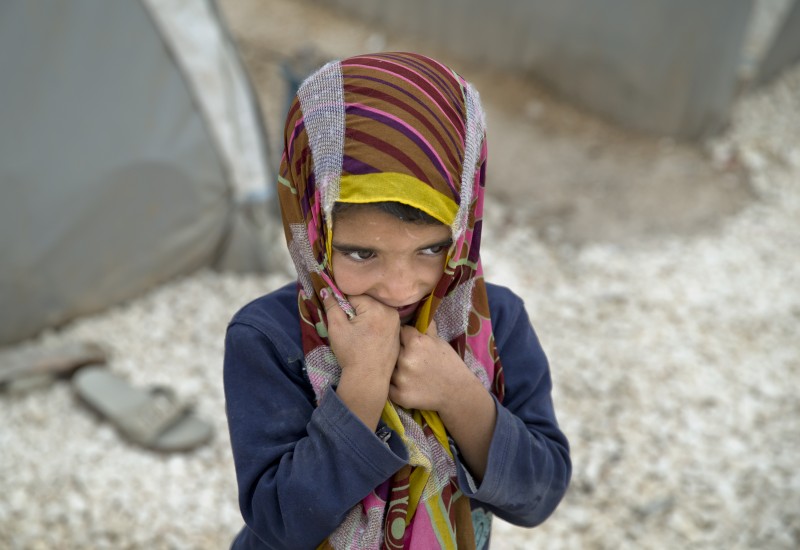 A Syrian Kurdish refugee child from the Kobani area stands next to tents on a cold morning at a camp in Suruc, on the Turkey-Syria border Monday, Nov. 17, 2014. Kobani, also known as Ayn Arab, and its surrounding areas, has been under assault by extremists of the Islamic State group since mid-September and is being defended by Kurdish fighters. (AP Photo/Vadim Ghirda)
