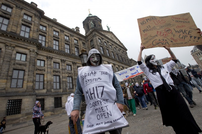 Supporters of the Million Mask March, dozens or hundreds of them on the march, wearing Guy Fawkes masks.