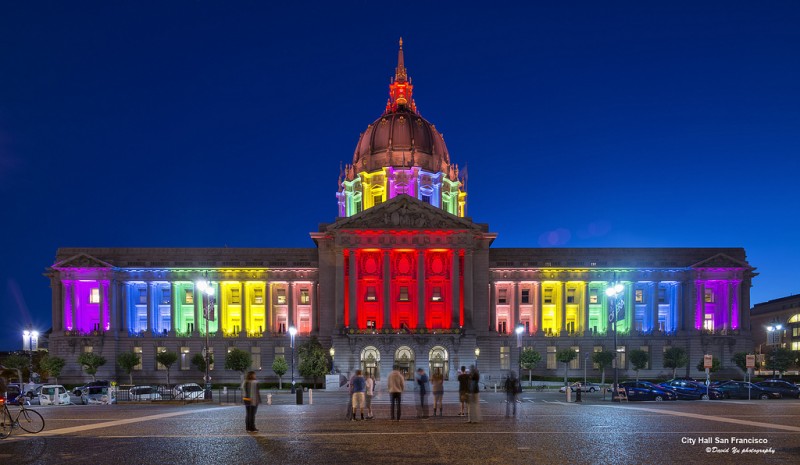 Rainbow lights illuminate San Francisco City Hall at night.