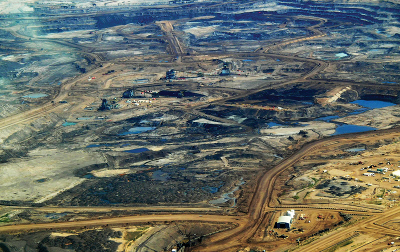 An overhead view of a desolate landscape strewn with mining runoff and piles of dirt and filth.