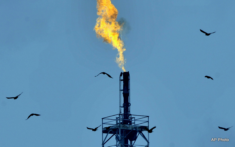 A smokestack belches flame as excess gas is burned off.