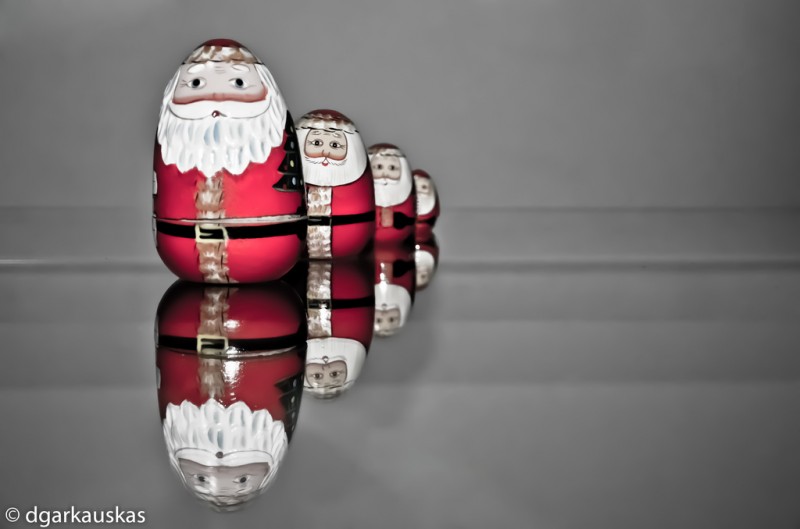 A series of dwindling reflections of a round, cartoonish Santa, as if seen in an infinite mirror.