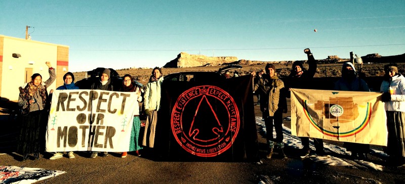 In early January, Diné youth activists began a 200-mile walk across their traditional lands to raise awareness about fracking and other harmful exploitation of the earth. Here a group are seen holding banners including Respect Our Mother and Respect Existence Or Expect Resistence - Indigenous Liberation. (Facebook / Nihígaal bee Iiná)