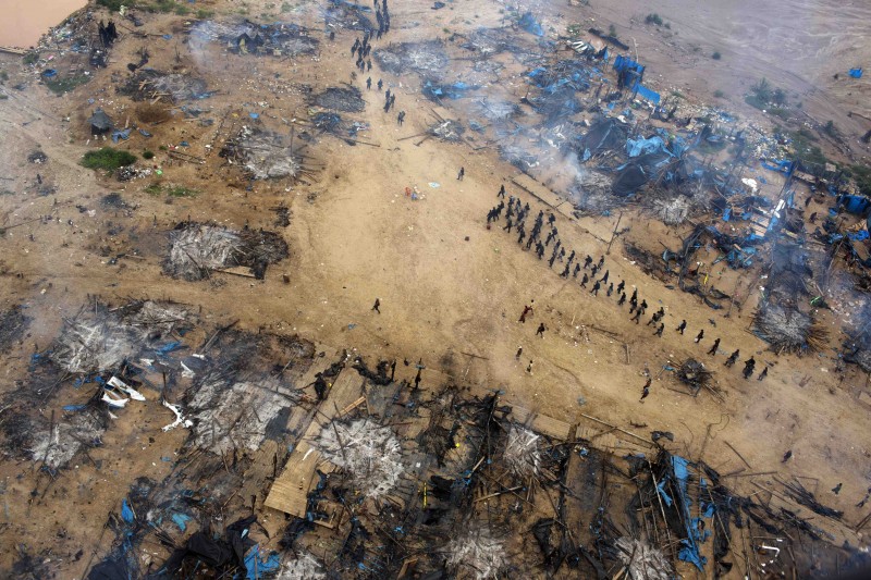 FILE - In this Nov. 12, 2014 file photo, a column of policemen move into a gold mining camp as part of an operation to eradicate illegal mining in the area known as La Pampa, in Peru's Madre de Dios region. Less than a month before Peru played host to global climate talks, the government sent police into southeastern jungles to dismantle illegal gold-mining mining camps. Fifty-thousand hectares of rainforest have been obliterated in the past six years in the wasteland known as La Pampa. (AP Photo/Rodrigo Abd)