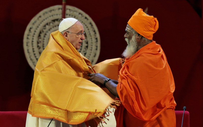 Sri Lankan Hindu priest Kurakkal Somasundaram, right, presents a shawl to Pope Francis during an inter-religious meeting in Colombo, Sri Lanka, Tuesday, Jan. 13, 2015. Pope Francis arrived in Sri Lanka Tuesday at the start of a weeklong Asian tour saying the island nation can't fully heal from a quarter-century of ethnic civil war without pursuing truth for the injustices committed. (AP Photo/Eranga Jayawardena)