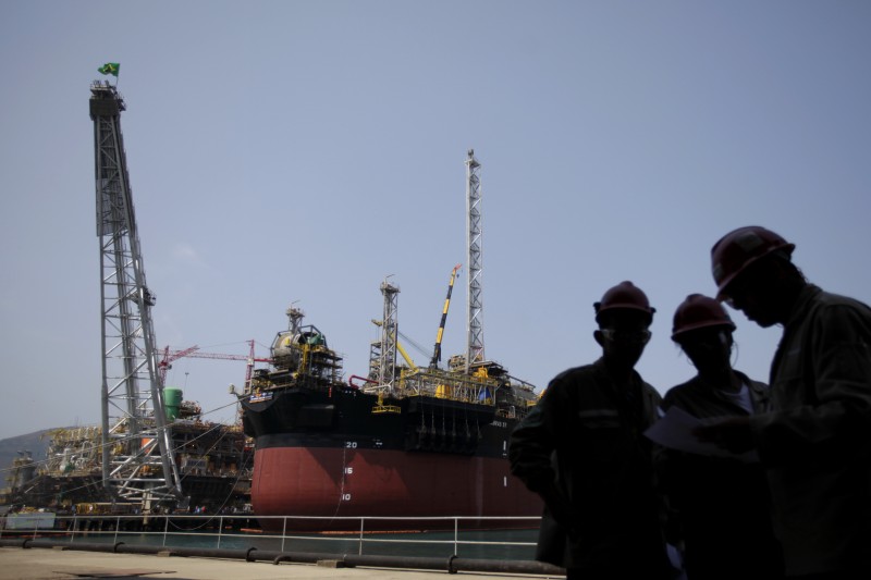 FILE - In this Sept. 22, 2010 file photo, workers stand by the construction of Petrobras oil platforms in the BrasFels shipyard in Angra dos Reis, Brazil. (AP Photo/Felipe Dana, File)