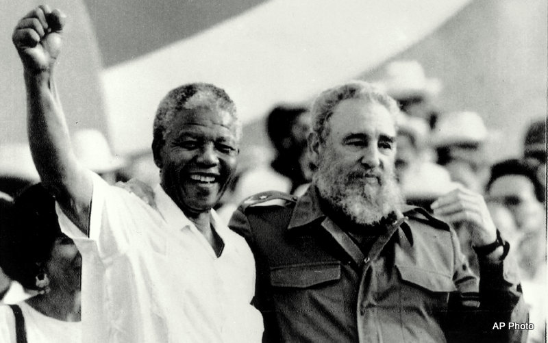 In this black and white photo, Nelson Mandela holds up a fist while embracing Fidel Castro with an arm around his shoulder during the celebration of the "Day of the Revolution" in Matanzas Saturday, July 27, 1991. Cuba's intervention was critical to allowing South Africa to overthrow the racist apartheid regime.
