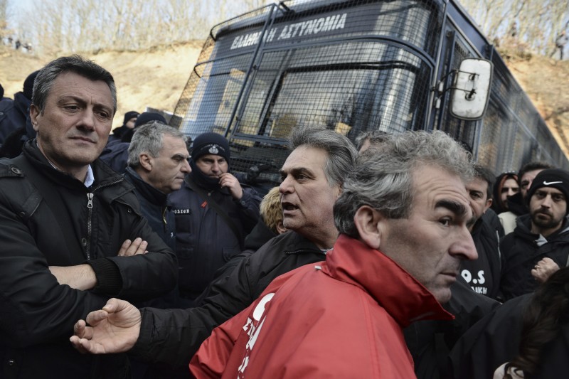 A man protesting against a gold mining operation tries to defuse tension in the northern Greek town of Skouries Sunday, Feb. 15, 2015. Two rallies, one in favor and one against the operation, were staged Sunday. The operation of the mine, in which a Canadian company has invested hundreds of millions of dollars, has been a contentious issue for years and the newly-elected leftist government has sided with the opponents. Supporters of the operation, including over 1,000 miners, say they and their families will barricade themselves in the mine shafts, if a shut down is decided. (AP Photo/Giannis Papanikos)