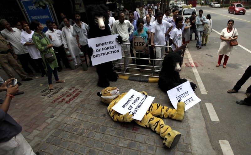 In this Tuesday, Sept. 11, 2012, file photo, Greenpeace activists dressed as wild animals hold placards during a protest outside the office of the Indian Coal Minister demanding a halt in allocation of forest land for coal mining, in New Delhi, India. A court has ordered the Indian government to release $300,000 sent by Greenpeace's foreign partners for use in India by the environmental group. (AP Photo/Altaf Qadri)