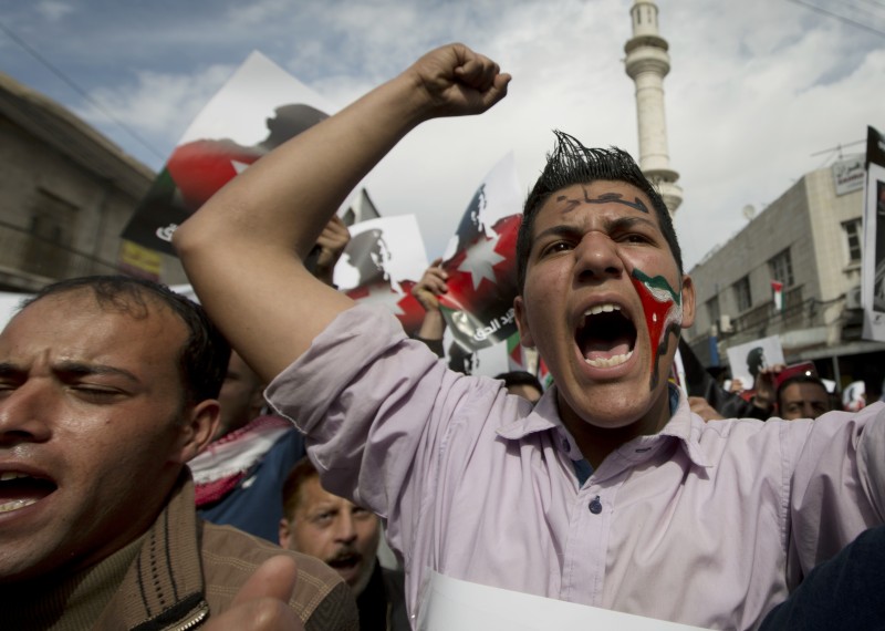 Demonstrators, one with a Jordanian flag image painted on his face and Arabic that reads, "Muath," as in slain Jordanian pilot, Lt. Muath al-Kaseasbeh, chant anti-Islamic State group slogans during a rally in Amman, Jordan, Friday, Feb. 6, 2015. Several thousand people marched after Muslim Friday prayers in support of King Abdullah II's pledge of a tough military response to the killing of the pilot. (AP Photo/Nasser Nasser)