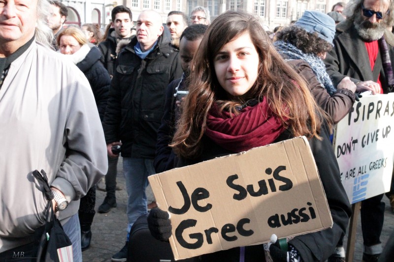 A woman at a February 15, 2015 anti-austerity rally in Amsterdam, Netherlands holds a sign reading "I Am Greek Also." Do the rise of parties like Syriza and Podemos signify a new awareness of global inequality? (Martin Broek / Flickr)