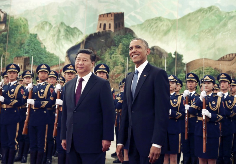 FILE - In this Nov. 12, 2014 file photo, U.S. President Barack Obama, right smiles as a group of children wave flags and flowers during a welcome ceremony held by Chinese President Xi Jinping at the Great Hall of the People in Beijing, China. Xi will make his first state visit as president to the United States in September, Chinese official media reported Wednesday, Feb. 11, 2015, underlining positive momentum in the often-troubled relationship between the worlds largest economies. (AP Photo/Andy Wong, File)