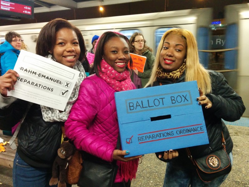 At Chicago's 95th Street Station, three women hold a ballot box and a paper ballot rejecting Mayor Rahm Emanuel and demanding reparations for police abuse, on February 21, 2015. These women joined activists in their protest after learning about the proposed ordinance. (Kelly Hayes)