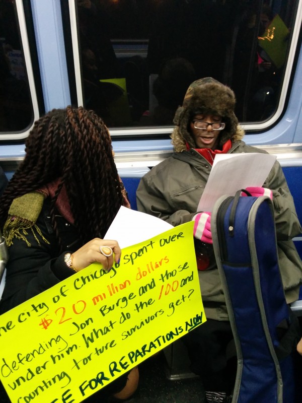 Chicago Light Brigade member Cairá Lee Conner discusses the reparations ordinance with commuters on the Chicago's Red Line commuter train on February 21, 2015. Activists asked passengers to symbolically vote against the mayor and for reparations. (Photo: Kelly Hayes)