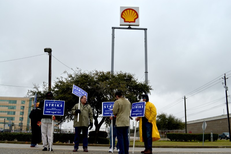 Oil workers holding picket signs in front of the Shell oil refinery in the Houston Ship Channel. The combined capacity of just three area refineries affected by the strike represents 10 percent of the United States' total oil refining ability. (Jane Nguyen)