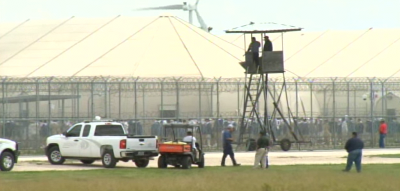 Thousands of immigrant prisoners gathered in the yard as officials lost control of the facility on February 20, 2015. Prisoners protested against unlivable conditions in the facility, which consisted of massive, overcrowded kevlar tents rather than more traditional buildings. (Screenshot / KGBT Action 4 News)