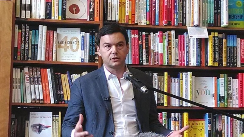 Thomas Piketty, author of "Capital in the Twenty-First Century," speaks at a microphone in Harvard Book Store in Cambridge, Massachusetts on April 18, 2014. Piketty's book argues that only a redistribution of global wealth can reverse the growth of inequality. (Wikimedia / Sue Gardner)