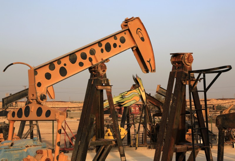 Old oil pumps, including one painted like a giraffe and another like a bird, stand in a scrap yard in the desert oil fields of Sakhir, Bahrain, Tuesday, March 3, 2015. The U.S. has so much crude that it is running out of places to put it, and that could drive oil and gasoline prices even lower in the coming months. (AP Photo/Hasan Jamali)