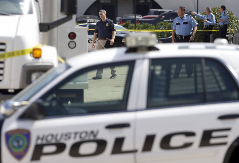 A Houston Police cruiser pulled up in front of a crime scene while, in the background, police and FBI agents work. Police Chief Charles McClelland seemed uninterested in responding to harsh criticism, including accusations of systemic racism and Houston police brutality, at a recent town hall meeting. (AP Photo/David J. Phillip)