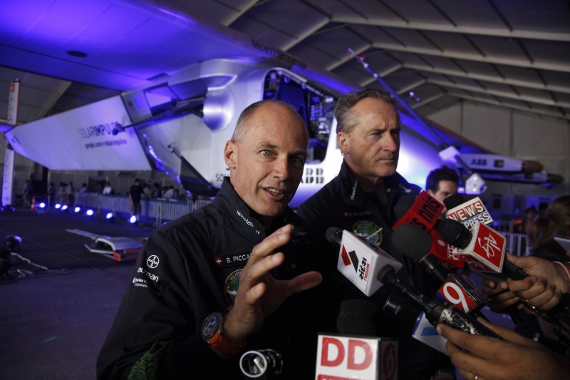Swiss pilots and founders of Solar Impulse 2 Bertrand Piccard, left, and Andre Boschberg address the media in front of the solar-powered airplane which landed Tuesday night in Ahmadabad, India, Wednesday, March 11, 2015. The  pilots of the solar-powered airplane on a historic round-the-world journey said Wednesday that they want the people of India to support their campaign for clean energy, a day after the aircraft landed in the country.(AP Photo/Ajit Solanki)