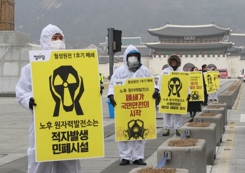 In this Thursday, Feb. 26, 2015, photo, environmentalists stage a rally against nuclear power plants near the government complex in Seoul, South Korea. The Nuclear Safety and Security Commission said Friday, Feb. 27 that seven of nine commissioners voted to approve to restart the Wolsong No. 1 reactor located in Gyeongju city, 275 kilometers (170 miles) south of Seoul. It was South Korea's first such decision since the meltdowns at Japan's Fukushima Daiichi reactors in 2011 raised safety concerns. The letters on banners read "Demand the Wolsong No. 1 reactor be permanently shut down." (AP Photo/Ahn Young-joon)