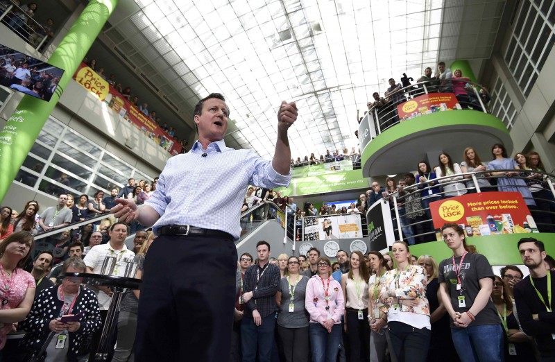 Britain's Prime Minister, and leader of the Conservative Party, David Cameron, centre, takes part in a campaign event at the headquarters of a supermarket chain in Leeds, northern England, Friday, May 1, 2015. The nation will vote in a General Election on Thursday, May 7. (Toby Melville/Pool Photo via AP)
