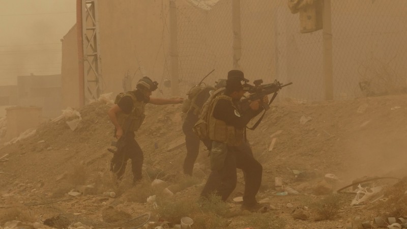 In this May 14, 2015 photo, security forces defend their headquarters against attacks by Islamic State extremists during sand storm in the eastern part of Ramadi, the capital of Anbar province, 115 kilometers (70 miles) west of Baghdad, Iraq. A new government intelligence briefing, released via FOIA request, reveals how the US government predicted the fall of Ramadi to ISIS, and even supported ISIS to help destabilize Syria. (AP Photo, File)