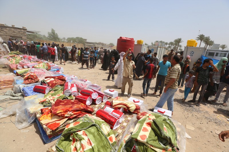 Displaced civilians from Ramadi wait to receive humanitarian aid from the United Nations in a camp in the town of Amiriyat al-Fallujah, west of Baghdad, Iraq, Friday, May 22, 2015. The United Nations World Food Program said it is rushing food assistance into Anbar to help tens of thousands of residents who have fled Ramadi after it was taken by Islamic State militant group. (AP Photo/Hadi Mizban)