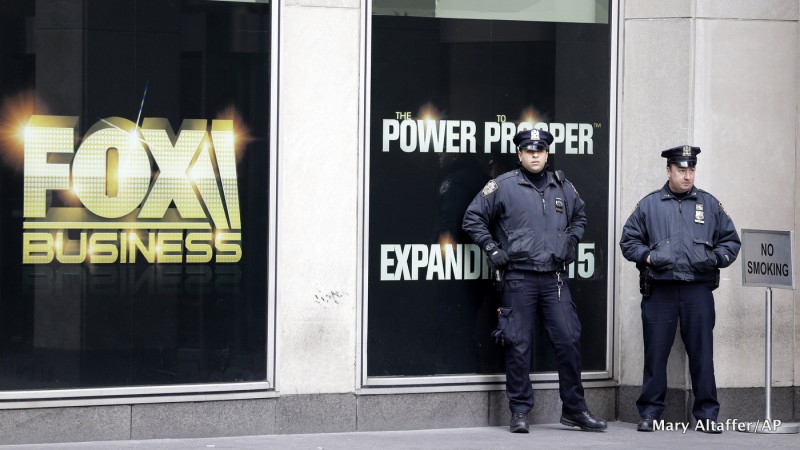 New York City police officers stand guard outside the building that houses Rupert Murdoch's News Corp headquarters in Midtown Manhattan on Friday, Jan. 16, 2015.
