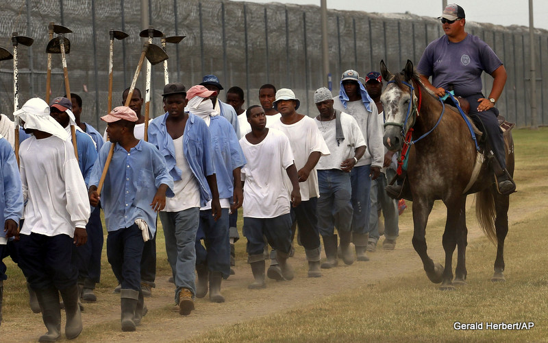 A prison guard on horseback watches inmates return from a farm work detail at the Louisiana State Penitentiary in Angola, La. America has more prisoners than any other country, even China, and that prison population is disproportionately black.