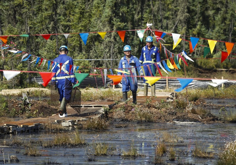 Flags hung over a pipeline leak to keep birds away as crews work to contain and clean up a pipeline spill at Nexen Energys Long Lake facility near Fort McMurray, Alta., Wednesday, July 22, 2015. A pipeline break discovered July 15 spilled more than a million gallons of a mixture of bitumen, water and sand at its Long Lake oilsands facility in northern Alberta. (Jeff McIntosh/The Canadian Press via AP)