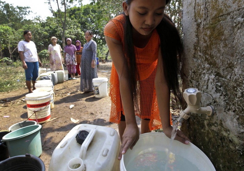 Indonesian women queue up to collect clean water from a public well in Tangerang, Indonesia, Wednesday, July 29, 2015. Several areas on the densely populated island of Java have been hit by drought during this dry season, forcing villagers to walk long distances to find clean water. (AP Photo/Tatan Syuflana)