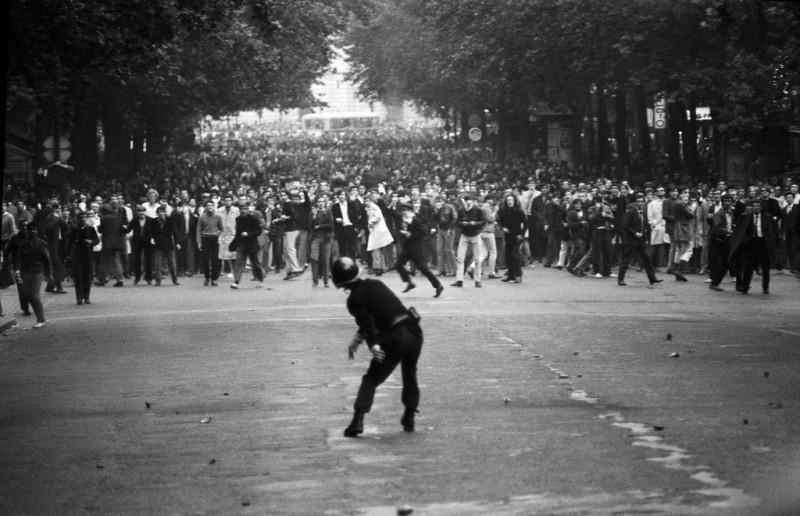 A police officer throws tear gas into a crowded march during the May 1968 Paris uprising. (Ailton Medeiros)