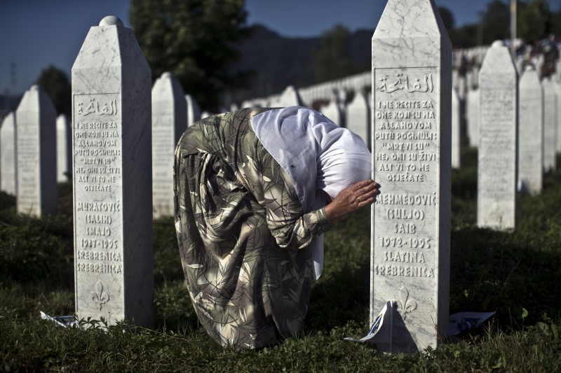 A woman weeps as she visits the grave of a family member at the Potocari memorial complex near Srebrenica, 150 kilometers (94 miles) northeast of Sarajevo, Bosnia and Herzegovina, Saturday, July 11, 2015. Twenty years ago, on July 11, 1995, Serb troops overran the eastern Bosnian Muslim enclave of Srebrenica and executed some 8,000 Muslim men and boys, which International courts have labeled as an act of genocide, and newly identified victims of the genocide are still being re-interred at Srebrenica. (AP Photo/Marko Drobnjakovic)
