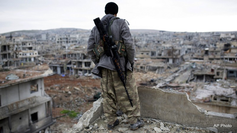File: A Syrian rebel sniper looks at the rubble in the Syrian city of Ain al-Arab. on Jan. 30, 2015.