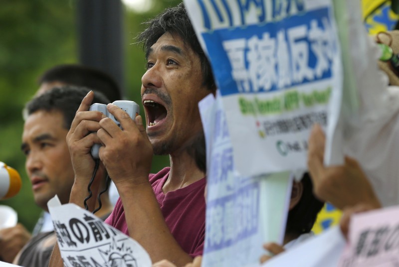 A protester shouts slogans during an anti-nuclear rally in front of Prime Minister's official residence in Tokyo, Tuesday, Aug. 11, 2015. Kyushu Electric Power Co. said Tuesday, it had restarted the No. 1 reactor at its Sendai nuclear plant as planned. The restart marks Japan's return to nuclear energy four-and-half-years after the 2011 meltdowns at the Fukushima Dai-ichi nuclear power plant in northeastern Japan following an earthquake and tsunami. (AP Photo/Shizuo Kambayashi)
