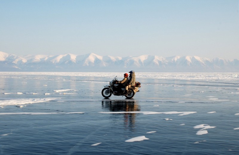 A motorcycle carrying two passengers drives across the frozen surface of Lake Baikal, Siberia on March 6, 2010. The Lake Baikal region suffered from devastating wildfires in recent days. (Flickr / The Adventurists)