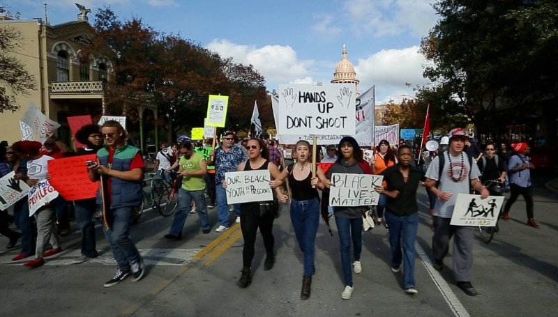 Kit O'Connell (middle left in a green t-shirt) covers a Black Lives Matter march using his smartphone as the protest marches down Congress Avenue in Austin, Texas on December 13, 2014. (Zgraphix / Jeff Zavala)