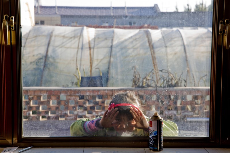 In this photo taken Oct. 10, 2015, a child peeps into the home of a family relocated from a drought region to the New Hongrui village in Pingluo county in northwestern China's Ningxia Hui autonomous region. The U.N. refugee agency says that people being displaced because of climate-related reasons are a growing global problem. Its pushing for greater awareness of their plight during a climate change conference in Paris opening Nov. 30. (AP Photo/Ng Han Guan)