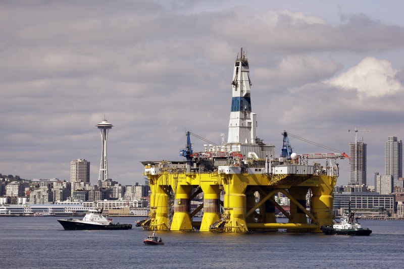 In this Thursday, May 14, 2015 file photo, the Royal Dutch Shell oil drilling rig Polar Pioneer is towed toward a dock in Elliott Bay in Seattle. Royal Dutch Shell reported a third quarter loss of $7.4 billion Thursday, Oct, 29, 2015 as it re-organized and canceled projects, including drilling in Alaska, to cope with the plunge in oil prices. The net loss compares with a profit of $4.5 billion in the same period last year. Shell reported $7.9 billion in charges, including $2.6 billion for Alaska and $2 billion related to the decision to cancel the Carmon Creek project in Alberta, Canada. Excluding one-time items and fluctuations in the value of inventories, the company said profit dropped to $1.8 billion, from $5.8 billion a year earlier, reflecting the plunge in oil prices. (AP Photo/Elaine Thompson, File)