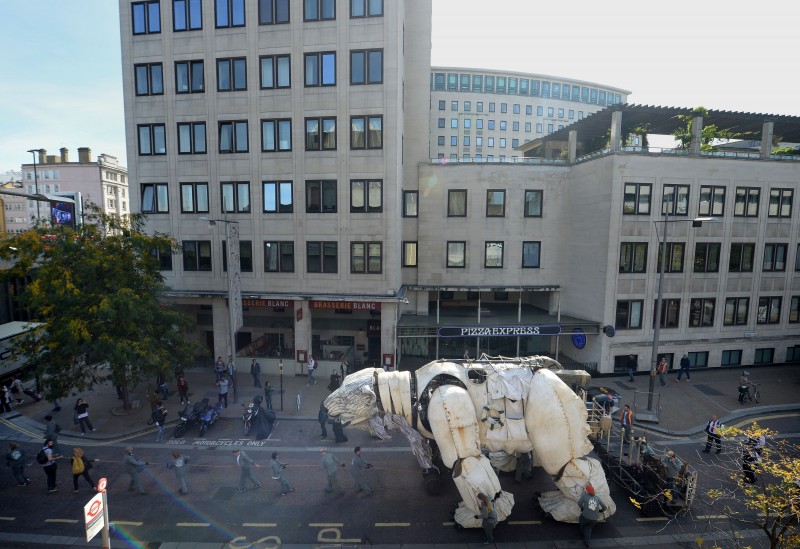 Puppeteers transport Aurora, the double decker bus sized polar bear, from in front of Shell HQ in London as Greenpeace activists celebrate Royal Dutch Shell's decision to stop Arctic oil drilling. Tuesday Sept. 29, 2015. Now Shell has announced its Arctic exit, the bear will be transported to Paris where the nations of the world will soon gather to negotiate a deal on climate change. See PA story ENVIRONMENT Shell. (Anthony Devlin/PA via AP)