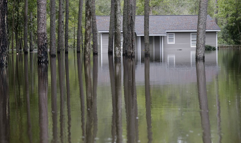 A home is surrounded by water during flooding on Roundtree Road along the Lynches River in Effingham, S.C., Tuesday, Oct. 6, 2015. The Carolinas saw sunshine Tuesday after days of inundation, but it could take weeks to recover from being pummeled by a historic rainstorm that caused widespread flooding and multiple deaths. (AP Photo/Gerry Broome)